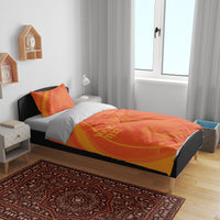 Orange duvet and pillowcases on bed, with swirl pattern and 'YOUR TEXT' design.