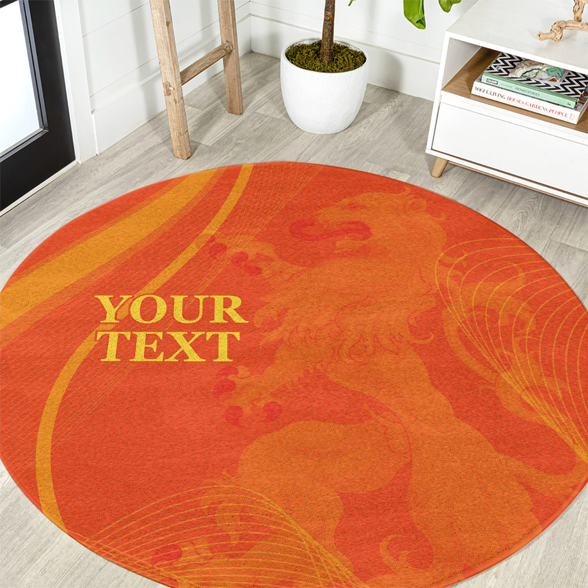Round orange rug with gold "YOUR TEXT" design and leaf-like pattern