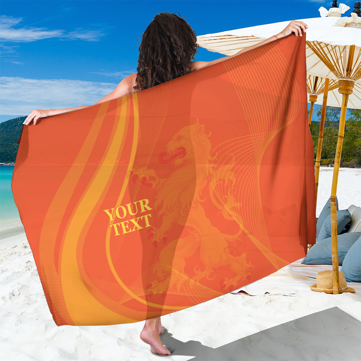 Orange sarong close-up with 'YOUR TEXT' print and tropical swirl design