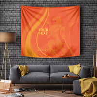 Orange rectangular wall tapestry with gold swirls and placeholder text, hanging on wall