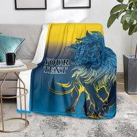 Lion print blanket in blue and yellow, draped over a couch with lion and mane design