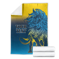 Lion print blanket in blue and yellow, with folded white towels beside it