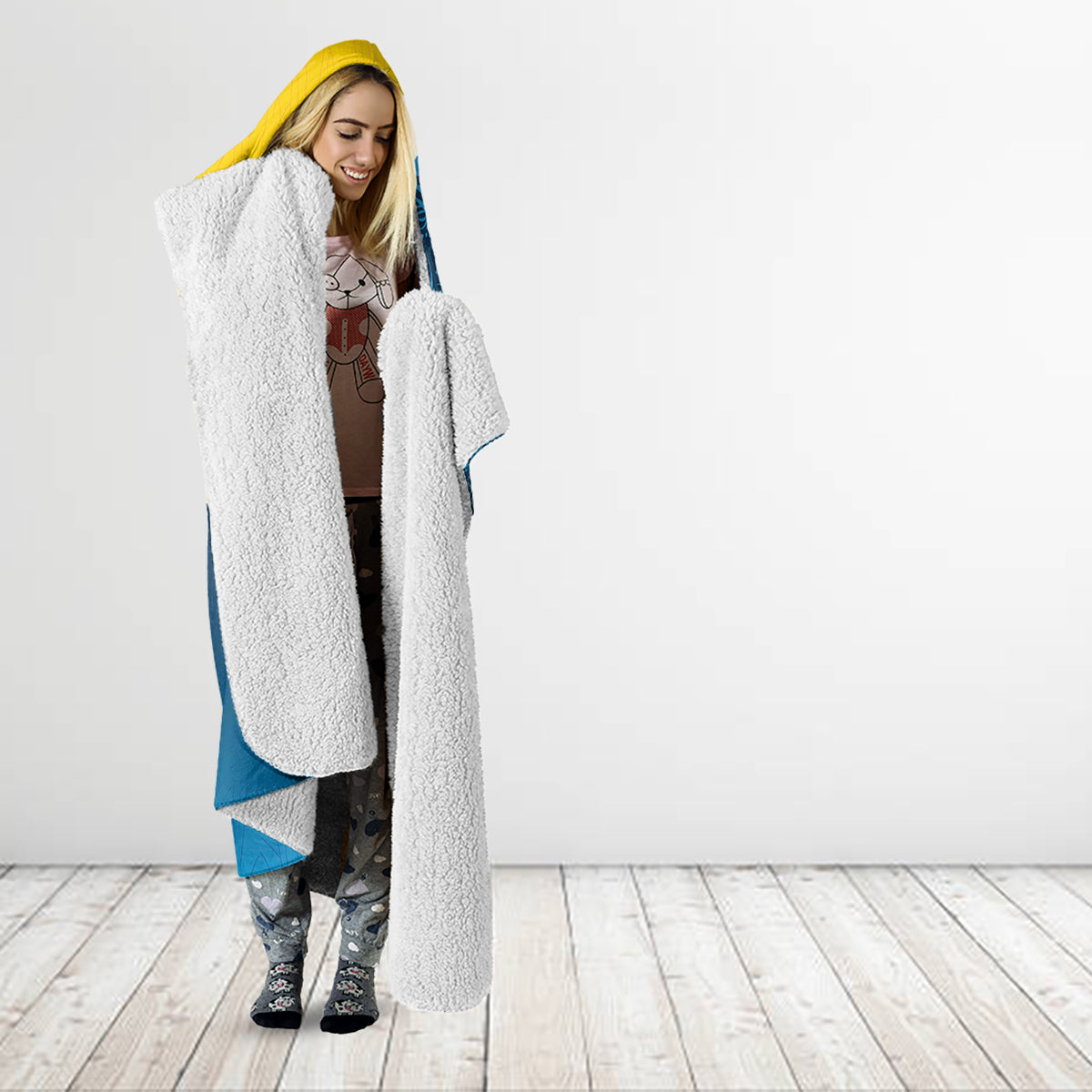 Hooded blanket, white plush lining and yellow hood over blue outer fabric