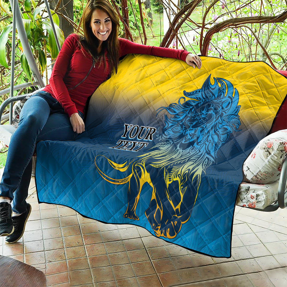 Quilt blanket draped on a sofa with blue-and-yellow quilting and blue lion image, “YOUR TEXT”