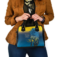 Blue and yellow handbag with lion graphic, black handles, and front text panel.