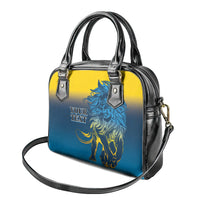 Blue and yellow structured handbag with black top handles, lion logo, and small tag details.