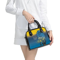 Blue and yellow shoulder handbag with black handles and lion graphic, carried by model.