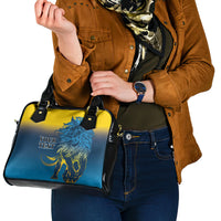 Blue and yellow shoulder handbag featuring lion artwork and black strap with metal buckles.