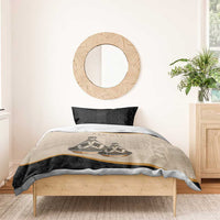 Bedding set duvet with beige tribal design, black sides, and gold stripe over bed.