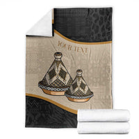 Folded personalized throw blanket with tajine dish pattern, beige/dark halves, gold trim