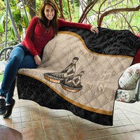 Black and beige quilt with diamond quilting, diagonal gold stripe, tribal dish figures