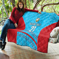 Blue and red cricket quilt draped over sofa, printed 'YOUR TEXT 21' and ball emblem.