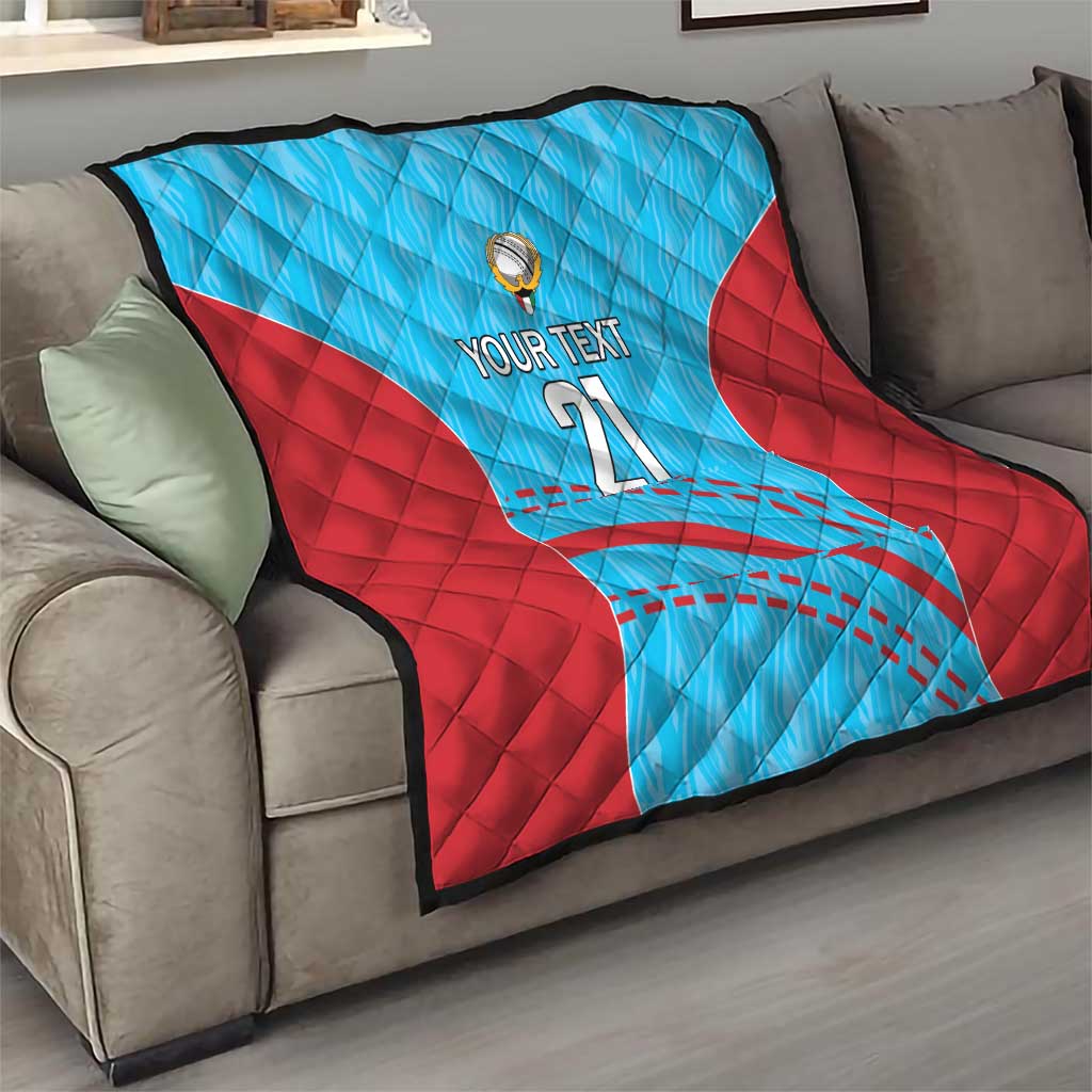 Blue and red cricket quilt on a couch with 'YOUR TEXT 21' and ball emblem at center.