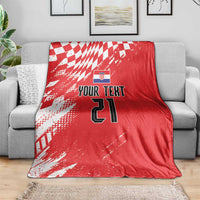 Red custom rugby blanket draped over sofa, white check pattern with “Your Text” and 21