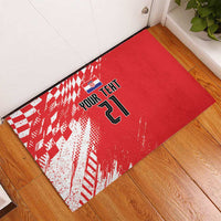 Red rubber doormat with white sporty pattern, team flag icon and number 21 on wood floor