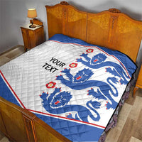 Blue and white quilt blanket with lion crests and red border on bed