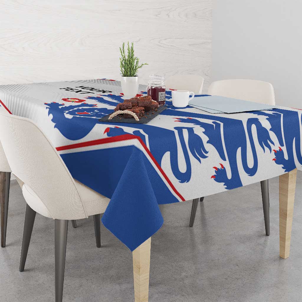 Football tablecloth with blue lion print and red/white border, covering a dining table.