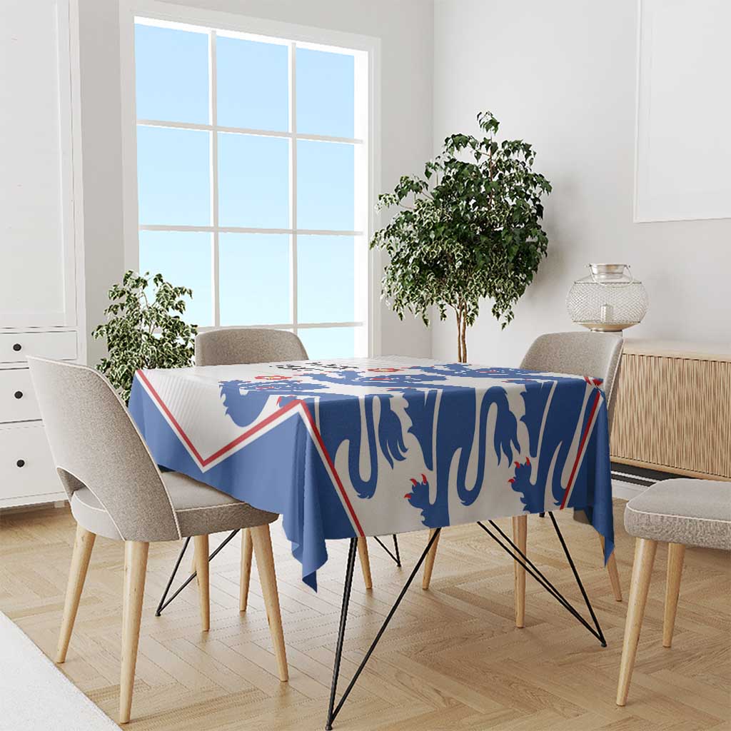 Football tablecloth with blue lion pattern and red/white border, draped on dining table.