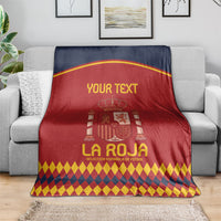Spain football blanket folded on couch, red and navy crest with diamond border