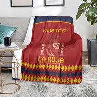 Spain football blanket on gray floor, red and navy crest and diamond pattern