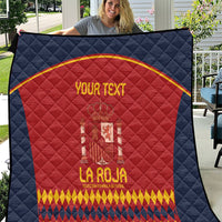Blue quilt with red Spain crest and gold text, diamond quilted pattern