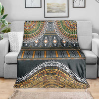 Ethnic tribal patterned blanket draped over a sofa in dark gray and gold tones