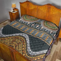 Ethnic bed quilt with black, gold, green and orange patterned design, quilted surface
