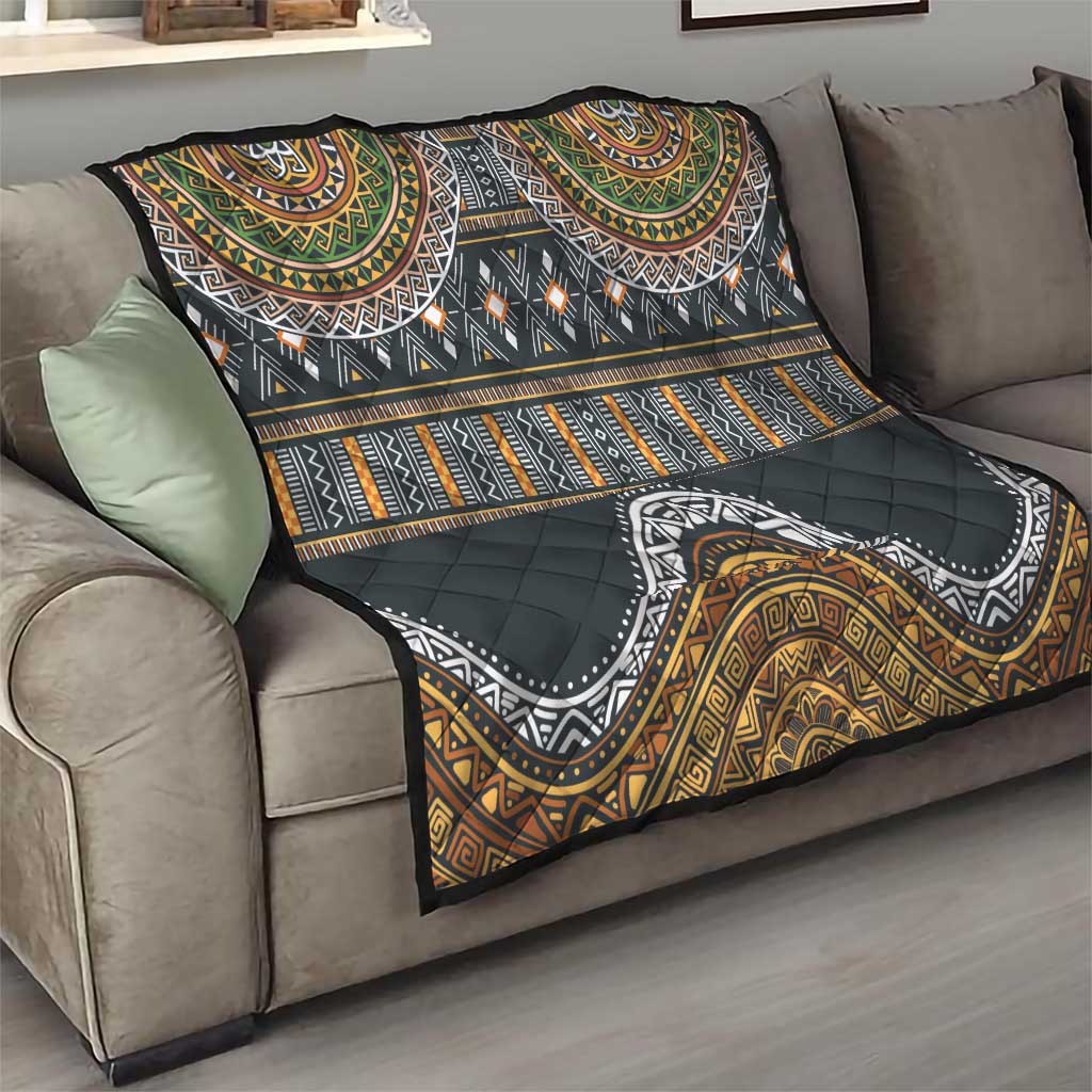 Ethnic throw quilt on sofa, black with gold, green and orange tribal patterns