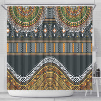 Ethnic tribal shower curtain with gold, green, orange and black patterns, hanging on rod