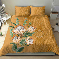 Gold bedding set with protea bouquet and decorative damask-style center motif on duvet