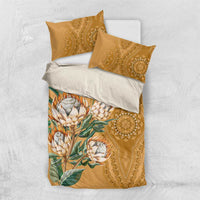 Gold bedding set with protea bouquet motif and decorative dashiki medallion on duvet
