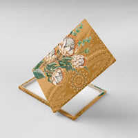 Diagonal view of gold protea canvas wall art with ornate border and green foliage