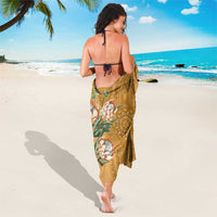 Gold dashiki-motif sarong worn as backless dress with tie straps and floral medallion