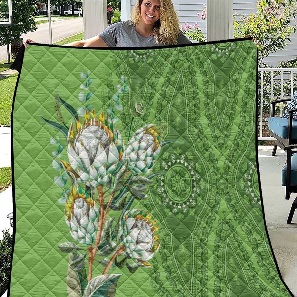 Green quilt with protea bouquet and mandala-style patterns, quilted diamond stitching.