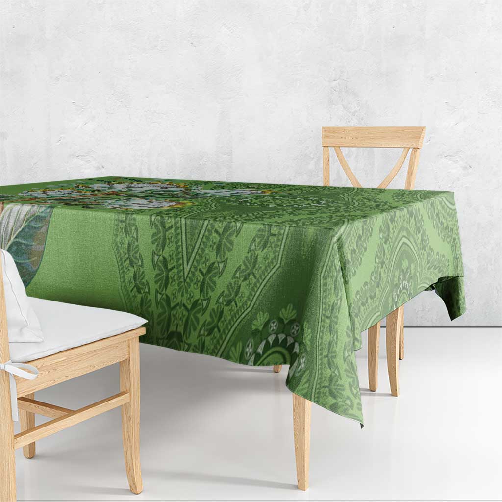 Green patterned tablecloth with woven-style dashiki motifs, draped over table