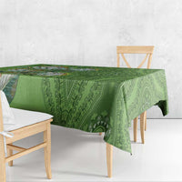 Green patterned tablecloth with woven-style dashiki motifs, draped over table
