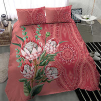 Peach duvet and pillow set with protea blossoms, green leaves, and red paisley border motif