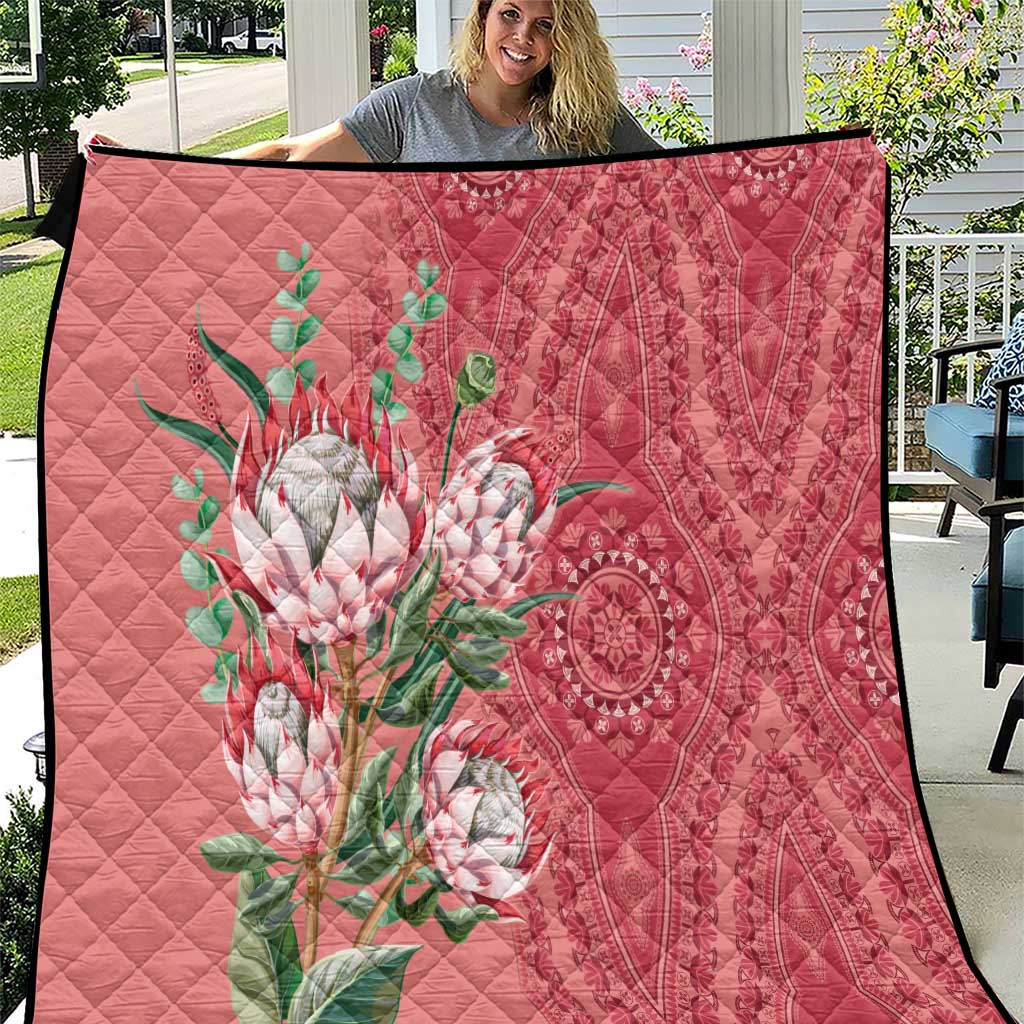 Peach quilt with dashiki-style protea floral motif, quilted diamonds, and black edge trim