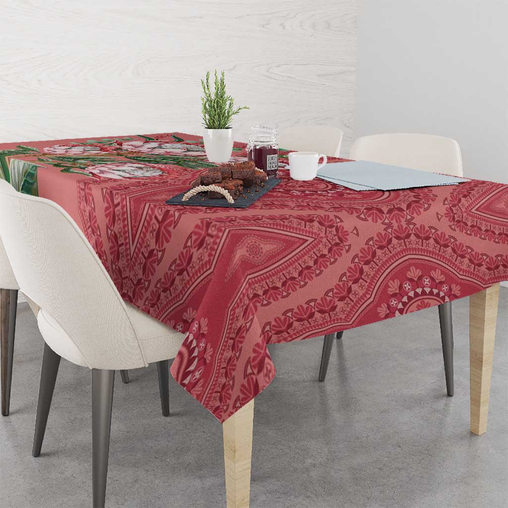 Peach dashiki motif tablecloth draped on dining table with protea floral accents
