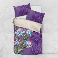 Violet bedding set with protea flower print and purple dashiki medallion pattern, layered pillows