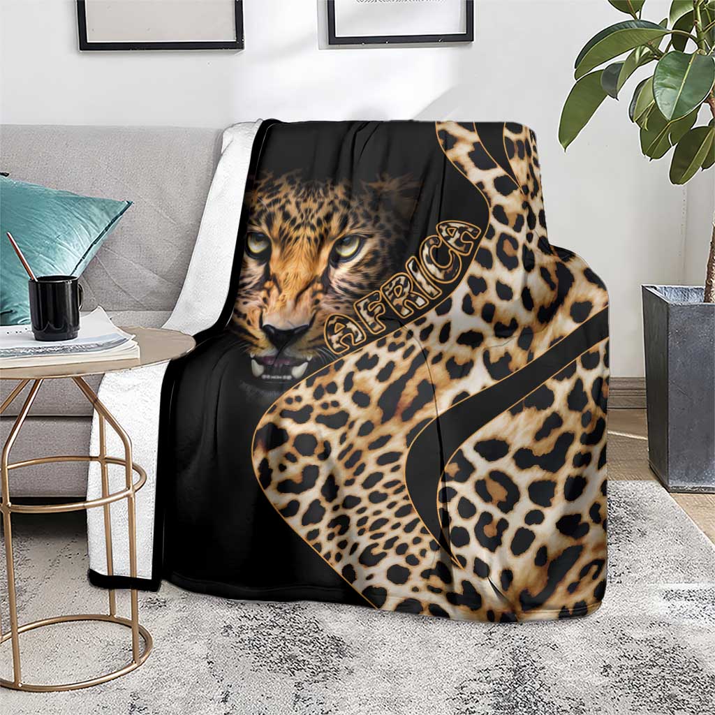 Black and gold leopard-pattern blanket draped over a chair with cat face design