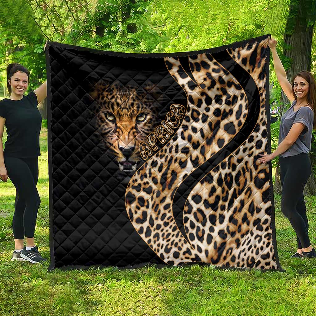 Leopard-themed black quilt with tan tiger face and brown spots, spread outdoors on green grass