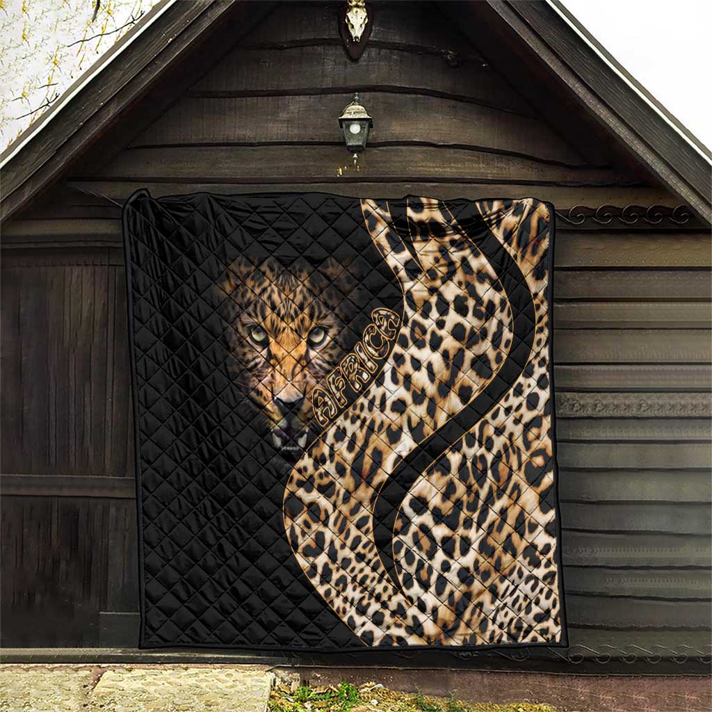 Black quilt blanket with leopard face and tan-and-brown spotted design, displayed on porch wall