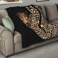 Black quilt blanket with leopard face and cream-brown spots, draped over a gray sofa