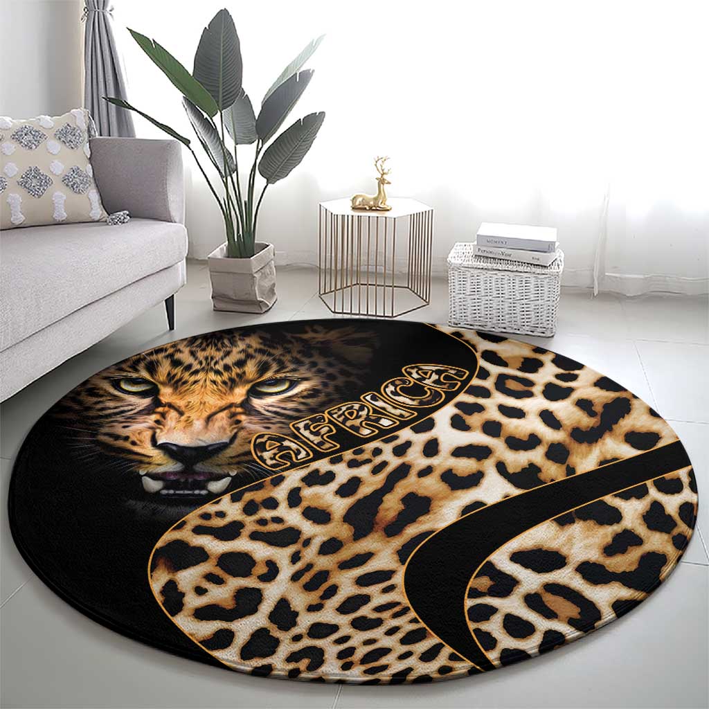 Round leopard-print carpet with cat face center, tan spots, and gold-toned swirl detail.