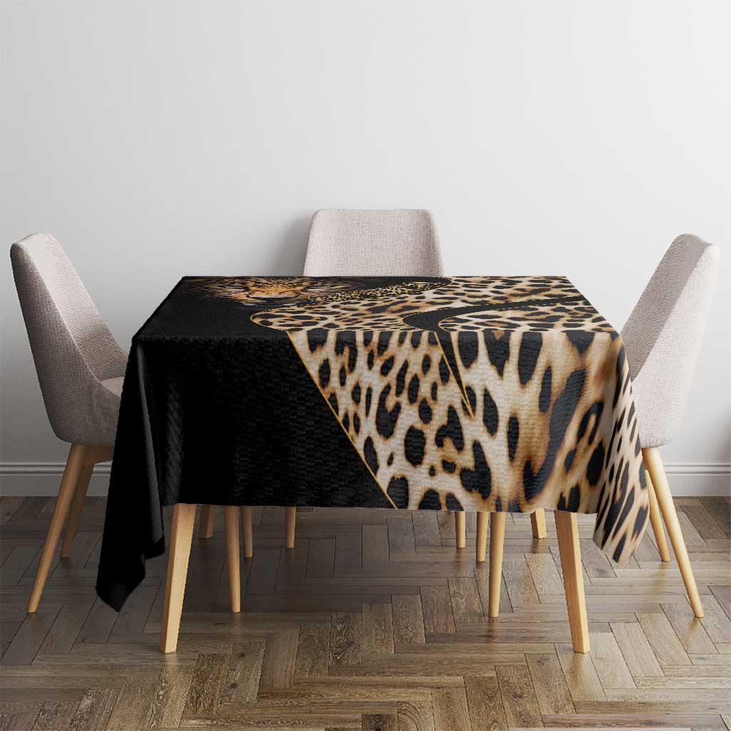 African leopard skin pattern tablecloth draped over square dining table, black and tan.