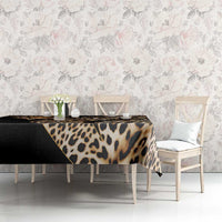 African leopard skin pattern tablecloth on table with floral design backdrop, black and tan.