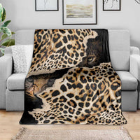 Leopard-print blanket with animal-face graphics, laid across a gray sofa