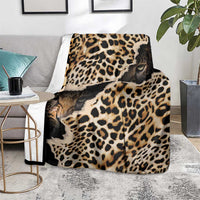 Black and tan leopard-print blanket with animal-face graphics, on a seat
