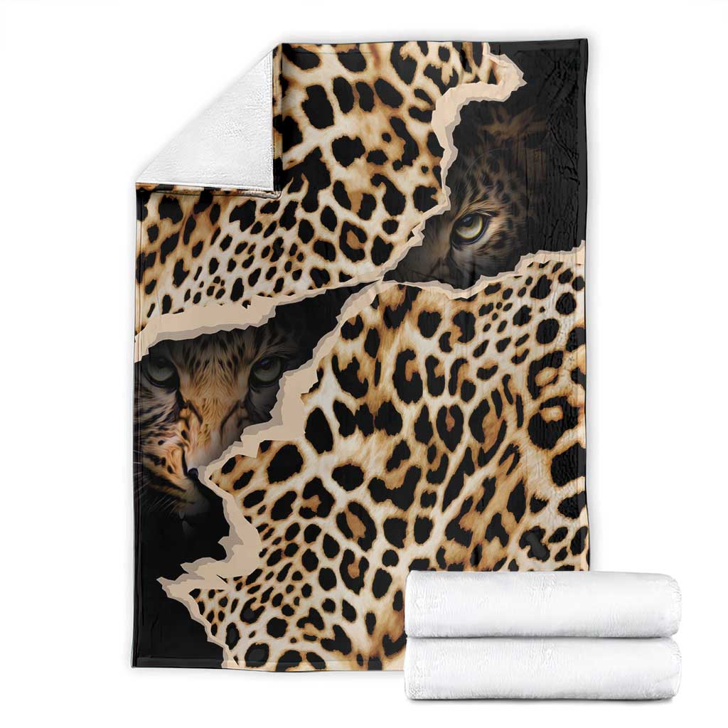 Leopard-print blanket with animal-face design, folded with white towels